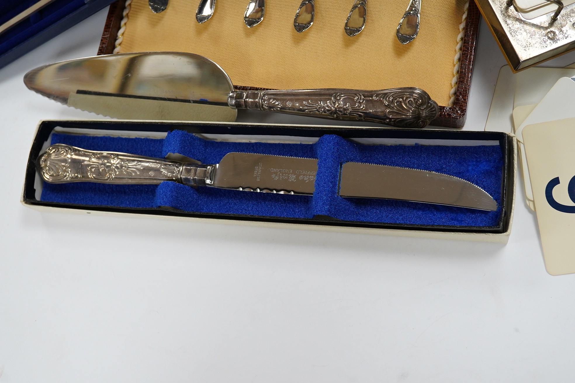 Sundry silver including a silver handled cake slice and similar bread knife, a cased set of six Italian 800 standard coffee spoons, a modern silver mounted desk calendar and an unusual 925 long olive spoon? with removabl